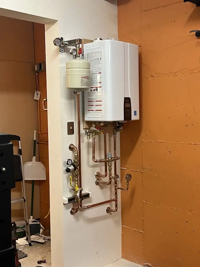 Plumbing technician inspecting water heater connections in Scotia